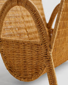 Close-up of Astrid magazine rack’s curved faux rattan handle and woven side panel