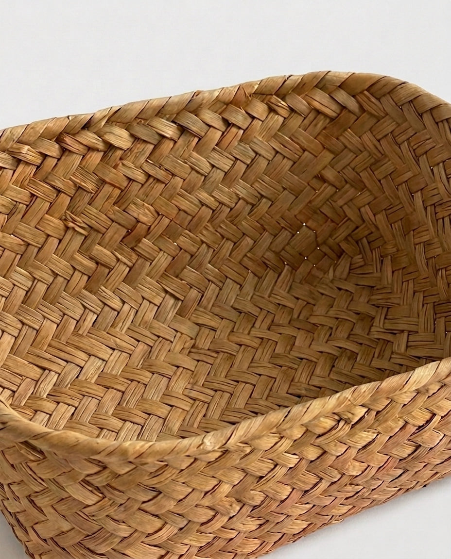 Close-up of Birgit cosmetic basket’s interlaced natural grass interior and reinforced rim