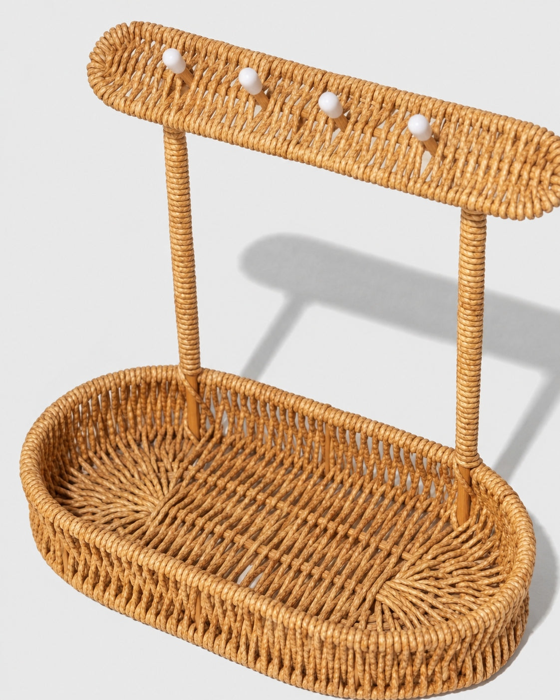 Einar faux rattan organiser showing four hooks above its shallow storage tray