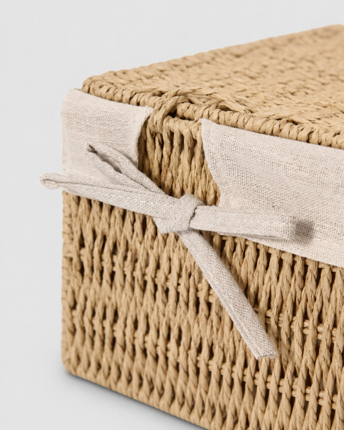 Close-up of Elva lidded storage box with woven lid and front ribbon detail