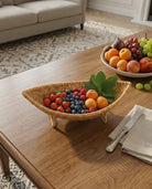 Haldor raised faux rattan fruit bowl styled with fruit on a dining table
