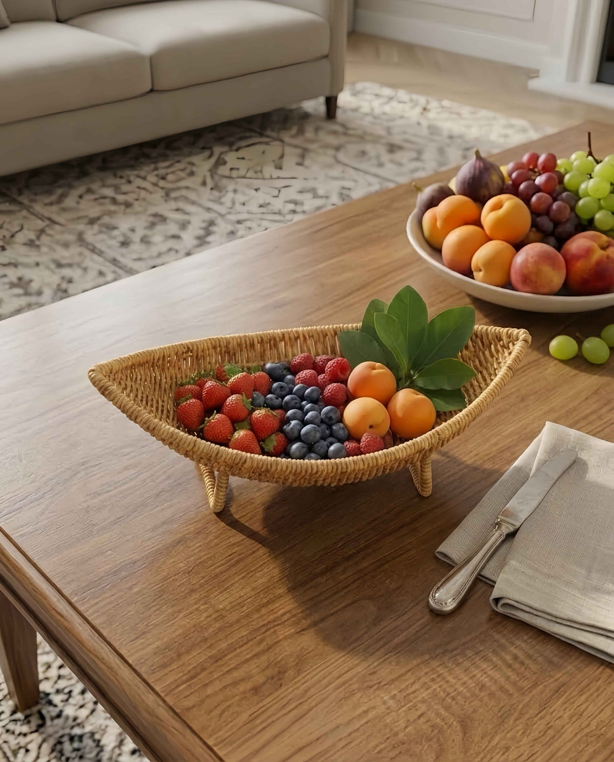 Haldor raised faux rattan fruit bowl styled with fruit on a dining table
