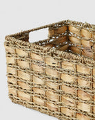 Close-up of Inga basket’s broad natural grass weave, braided edge and integrated handle opening