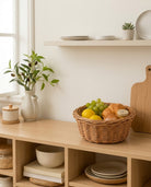 Mona faux rattan fruit storage basket holding fruit and packaged bread on a kitchen shelf