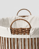 Close-up of Nora laundry basket’s faux rattan handle and off-white fabric liner