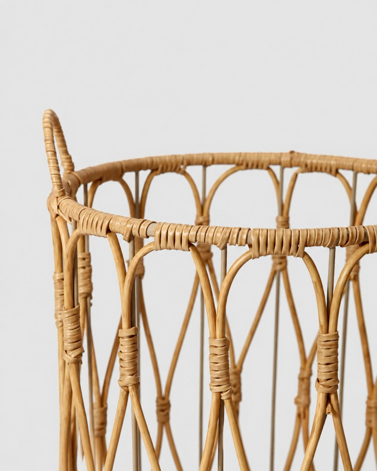 Close-up of Thea basket’s wrapped faux rattan rim and curved open-weave detail