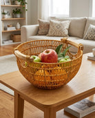 Viggo faux rattan fruit basket holding apples on a living-room coffee table